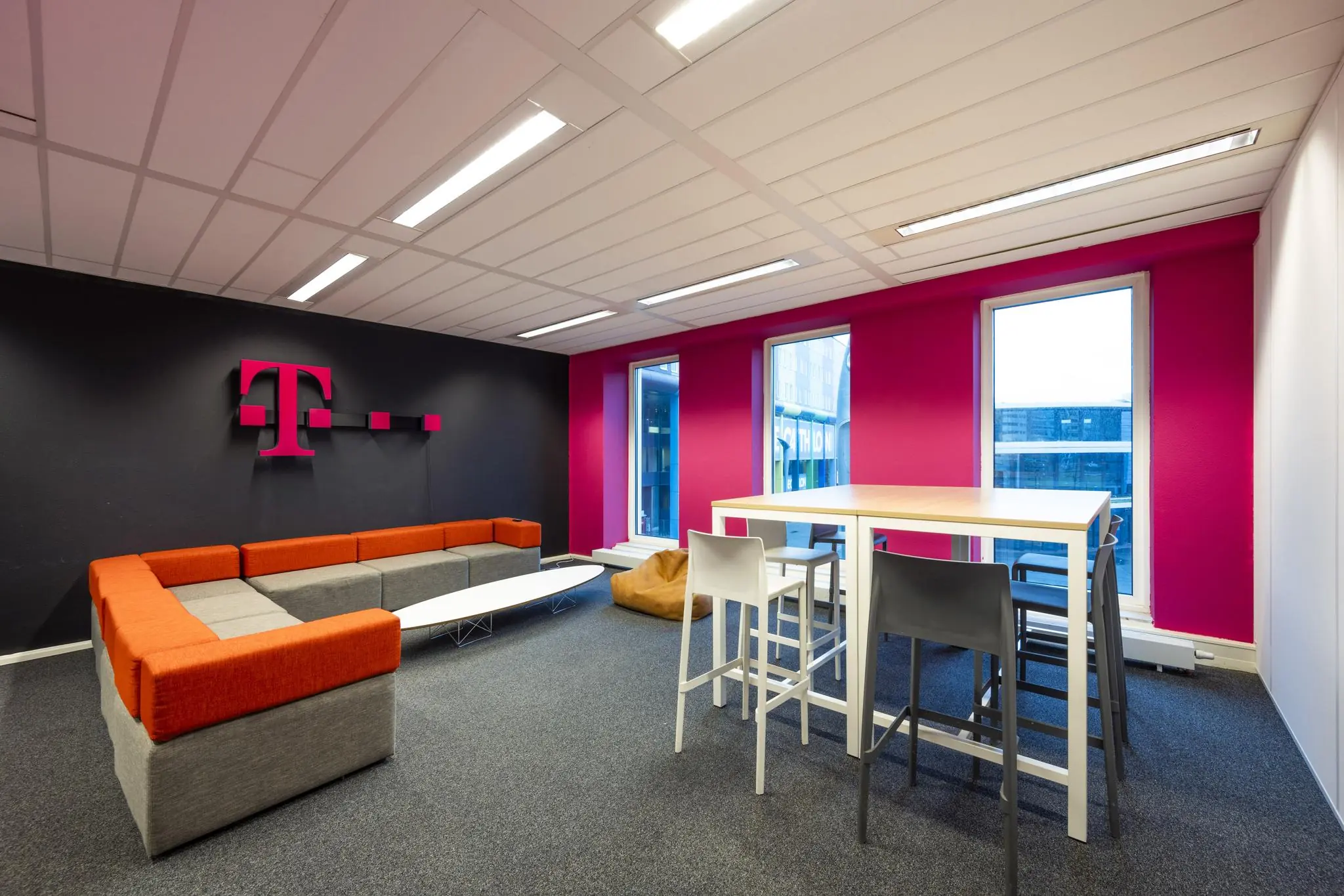 Moderne lounge- en werkruimte met T-Mobile branding aan de Johan Cruijff Boulevard.